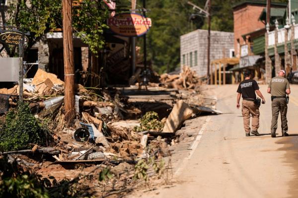 Two Sheriff deputies walk on the main street in the aftermath of Hurricane Helene, Wednesday, Oct. 2, 2024, in Chimney Rock Village, N.C.