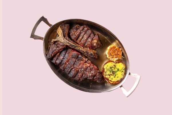 A plate of steaks with a side dish